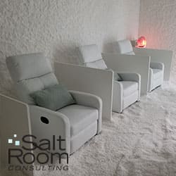 A salt room with three comfortable white lounge chairs