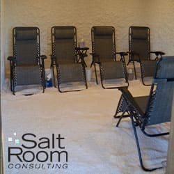 A salt room with five dark lounge chairs